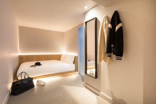 a small room with a bed and a mirror at Zedwell Underground Hotel Tottenham Court Rd in London
