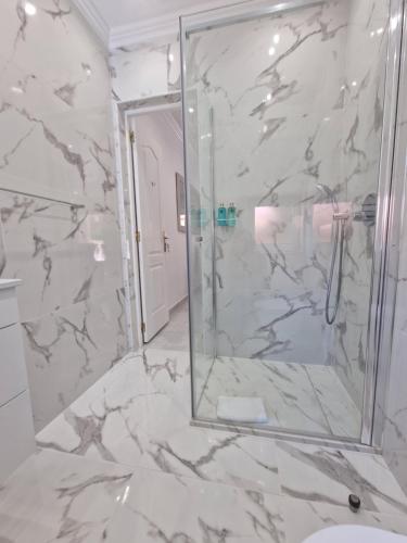 La salle de bains est pourvue d'une douche avec une porte en verre. dans l'établissement Quinta do Baía, à Lagos