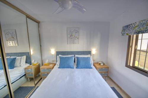 een slaapkamer met een groot bed met blauwe kussens bij Riviera, La Cala de Mijas, Terrace & Pool in Málaga