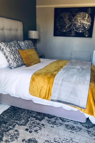 1 dormitorio con 1 cama grande con manta de oro en BoKáro Boutique Guesthouse, en Prieska