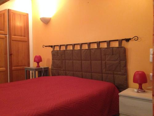 a bedroom with a bed with a red bedspread at appartement 30m2 calme proche du centre ville in Lunel
