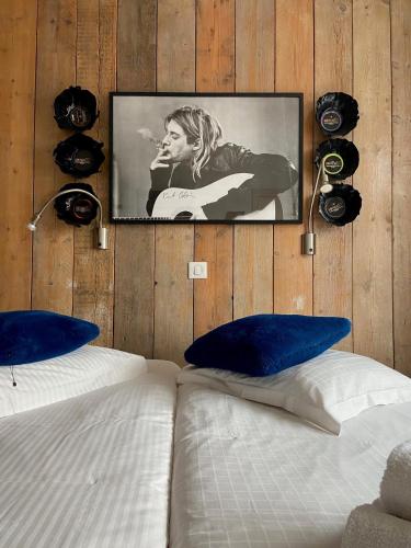 a tv hanging on a wooden wall above a bed at Hotel Aan Zee in De Panne
