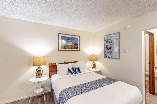 Lamplighter Inn في باندون: غرفة نوم مع سرير وطاولتين مع مصابيح