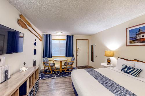 a hotel room with a bed and a table at Lamplighter Inn in Bandon