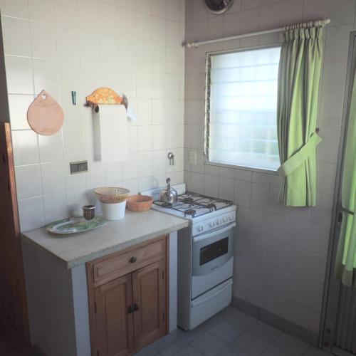 een kleine keuken met een fornuis en een raam bij Casa en Alquiler Temporario in Olavarría