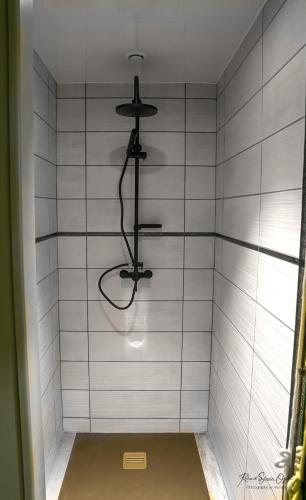 a shower with a white tiled wall at CASA UPUPA in Montreuil