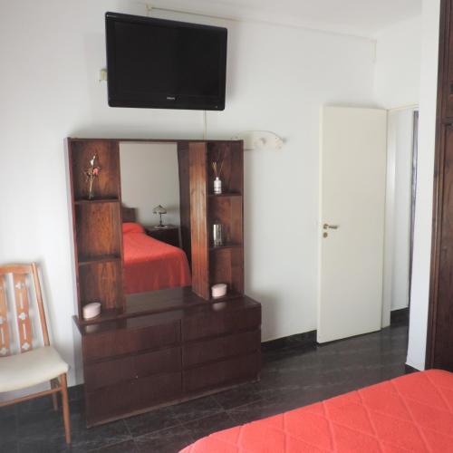 ein Schlafzimmer mit einem Bett und einem TV auf dem Spiegel in der Unterkunft Casa en Alquiler Temporario in Olavarría