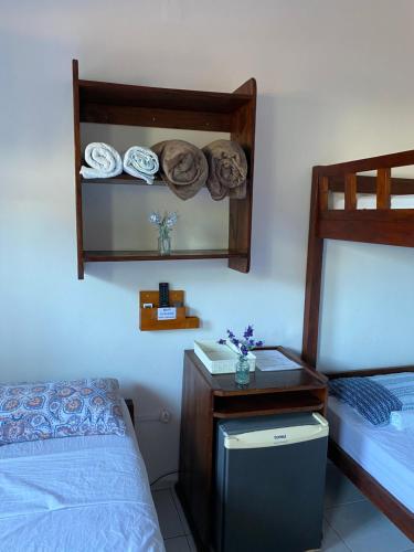a bedroom with a bed and a table with a mirror at Estalagem Sol de Boipeba in Ilha de Boipeba