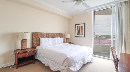 1 dormitorio con 1 cama y ventana con balcón en Ocean Club 306, en Biloxi