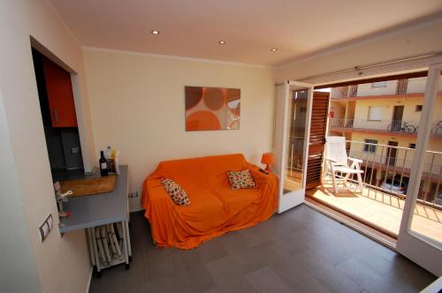 um quarto com uma cama laranja e uma varanda em Mare Nostrum 2D 324 em Torroella de Montgrí