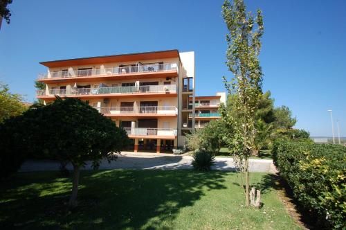 um edifício de apartamentos alto com árvores em frente em Mare Nostrum 3D 541 em Torroella de Montgrí