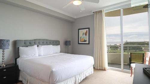 a bedroom with a large bed and a large window at Ocean Club 502 in Biloxi