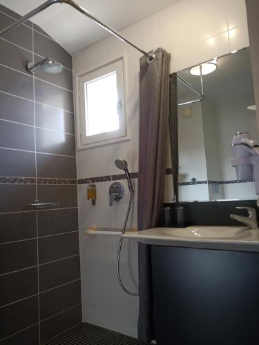 une salle de bain avec une douche, un lavabo et un miroir dans l'établissement Hôtel La Marisa Grande Plage, à Saint-Jean-de-Luz