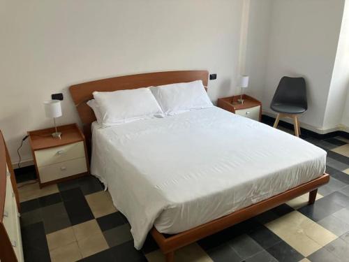 een slaapkamer met een bed met 2 nachtkastjes en een stoel bij A 100 passi da Piazza Bra in Verona