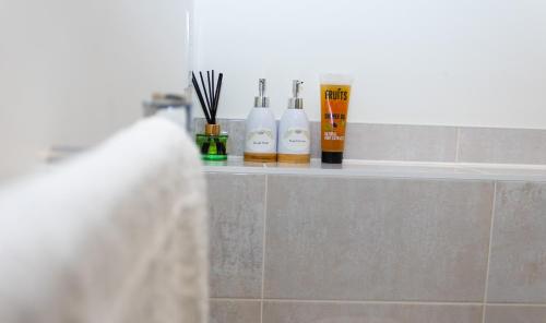 a shelf in a bathroom with three shampoo bottles at Luxurious MK Apartment-Campbell Park in Milton Keynes
