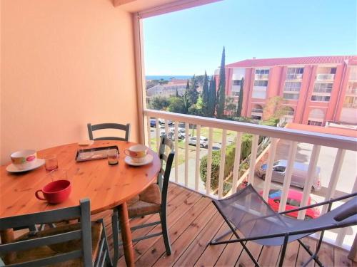 d'une table et de chaises en bois sur un balcon avec vue. dans l'établissement Appartement l'Evasion, vue mer, plages à pied, à Fréjus