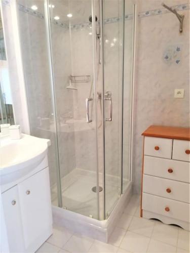 une salle de bain blanche avec une douche et un lavabo dans l'établissement Appartement l'Evasion, vue mer, plages à pied, à Fréjus