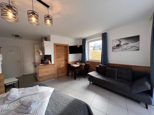 a bedroom with a bed and a couch and a table at Studio Rehkitz by Interhome in Kaprun
