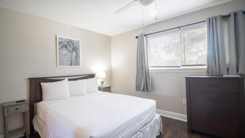 een slaapkamer met een wit bed en een raam bij Oak Shores 63 in Biloxi