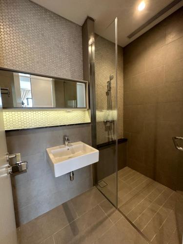 y baño con lavabo y ducha acristalada. en Lucentia residence T1, en Kuala Lumpur