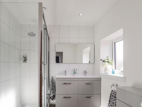 a white bathroom with a sink and a mirror at Firthview in Nairn