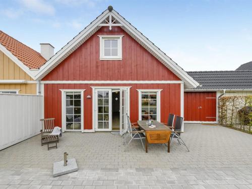 Casa roja con patio con mesa y sillas en Holiday Home Bleike - 250m from the sea in Funen by Interhome en Bro