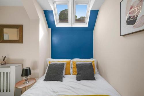 a bedroom with a bed with a blue wall at The Central Winchester Gem - Sleeps 2 in Winchester