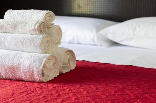 einen Stapel Handtücher auf einem Bett neben in der Unterkunft Hotel Kennedy in Bellaria-Igea Marina