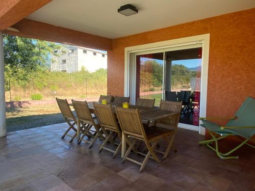 uma sala de jantar com mesa e cadeiras em "Villa Bernardini" vacances paisible à 2km de la mer em Ventiseri