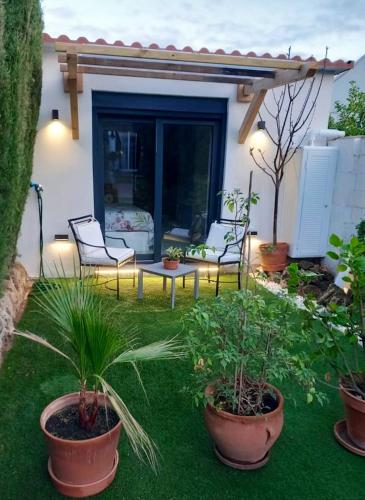 a patio with two chairs and a table and plants at Studio with furnished terrace at Riogordo in Ríogordo