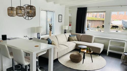 a living room with a couch and a table at Woonboot 4 Harderwijk in Harderwijk