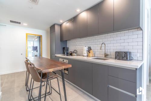 a kitchen with a wooden table and a sink at Downtown Miami Condos by Lua Host in Miami