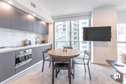 a kitchen with a table and chairs and a tv at Downtown Miami Condos by Lua Host in Miami