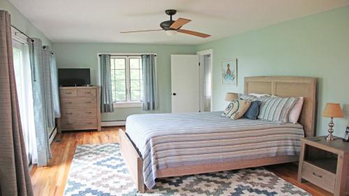 a bedroom with a bed and a ceiling fan at 160 Long Pond Drive Harwich Cape Cod - Old Camp in Harwich