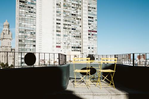a table and chairs on a balcony with tall buildings at Viajero Montevideo Hostel in Montevideo
