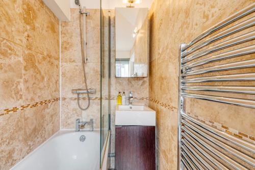 bagno con vasca e lavandino di Loft Piccadilly Circus Apartment a Londra
