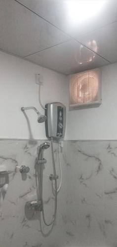 uma casa de banho com um chuveiro e uma televisão na parede em Sudunelum Holiday Resort em Anuradhapura