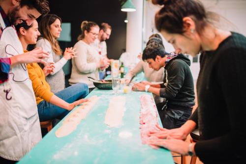 a group of people standing around a table cutting a cake at Viajero Montevideo Hostel in Montevideo