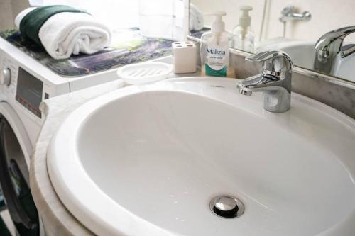 a white bathroom sink with a towel on a counter at Free public parking BumbleBee Apartment 4ppl AC FastNet TV in Budapest