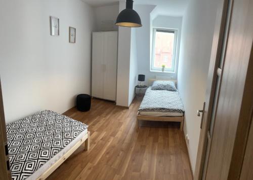 - une chambre avec 2 lits et une fenêtre dans l'établissement Kamienica5, à Chorzów