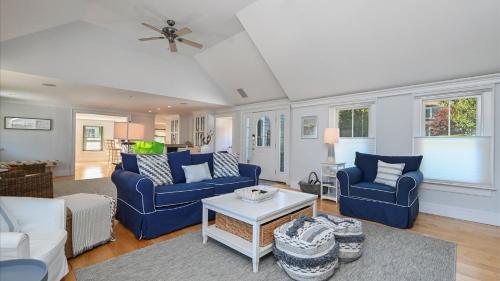 a living room with two blue chairs and a table at 201 Main Street Chatham Cape Cod - - Sandpiper in Chatham