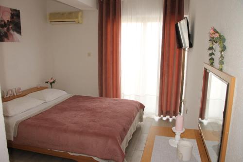 a bedroom with a bed and a television and a window at Motel "Tri lovca" in Knin