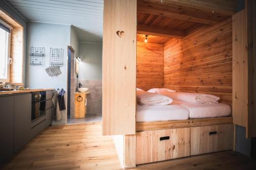 een slaapkamer met een bed in een houten kamer bij Tauernlust Outdoor & Relax in Mallnitz