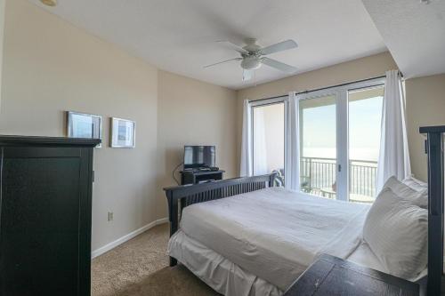 een slaapkamer met een bed, een plafondventilator en een raam bij Legacy II 1206 in Gulfport