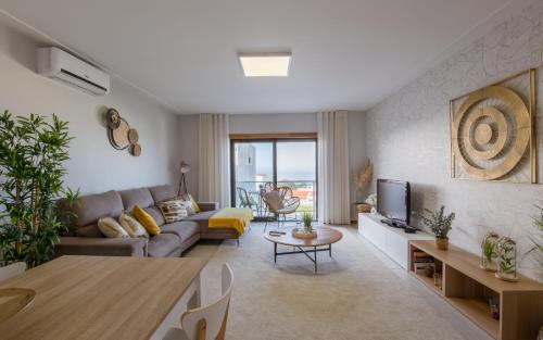 a living room with a couch and a tv at Panoramic Villa Mar in Nazaré