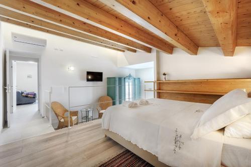 a bedroom with a large bed and wooden ceilings at HyblaLifeRooms in Ragusa