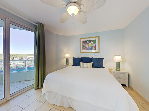 a bedroom with a white bed and a large window at Silver Beach 506 orange Beach in Orange Beach