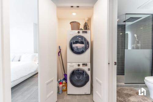 a washer and dryer in a room with a bed at Downtown Miami Condos by Lua Host in Miami