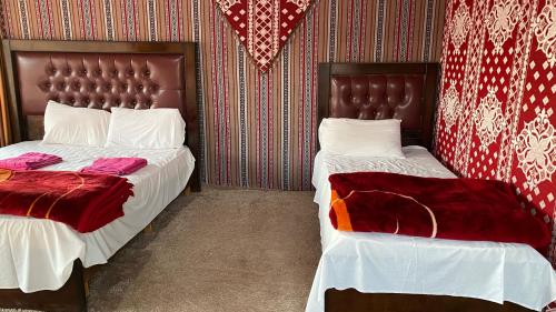 two beds sitting next to each other in a bedroom at Wadi Rum Khalid luxury camp in Wadi Rum