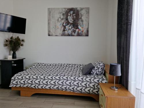 クニンにあるMotel "Tri lovca"のベッドルーム1室(ベッド1台付)が備わります。壁には絵画が飾られています。